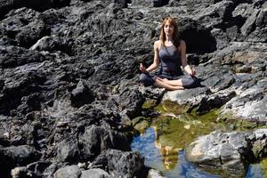 jovem e bela mulher fazendo ioga na natureza foto