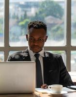 retrato do jovem empresário negro trabalhando no escritório foto