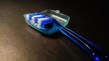 escova de dentes azul em fundo preto foto