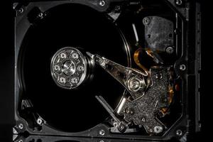 unidade de disco rígido desmontada e aberta, vista interna com reflexões, isoladas em preto foto