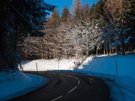 estrada na floresta de neve de inverno. montanhas dos vosges. foto