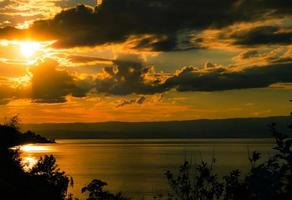 lindas cores do pôr do sol sobre o lago genebra, o reflexo do sol poente na água, a atmosfera de paz e tranquilidade foto