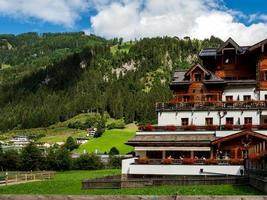 colinas verdes de um resort alpino na áustria no verão. pequena vila, hotéis e chalés, todos em cores. belos terraços e painéis solares nos telhados. a proximidade da civilização e da natureza pura. foto