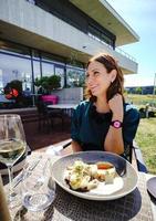 mulher jovem e bonita no terraço aberto do restaurante com um copo de vinho foto