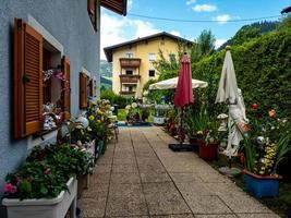 colinas verdes de um resort alpino na áustria no verão. pequena vila, hotéis e chalés, todos em cores. belos terraços e painéis solares nos telhados. a proximidade da civilização e da natureza pura. foto