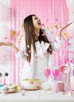 mulher bonita comemorando festa de aniversário jogando confete rosa foto