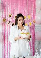 mulher bonita comemorando festa de aniversário segurando um bolo
