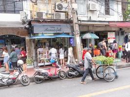 silom bangkokthailand16 de agosto de 2018 de manhã as pessoas estão caminhando para o trabalho e fazendo atividades como comprar café para comprar ou comprar bilhetes de loteria e fazer fila para uma motocicleta. foto