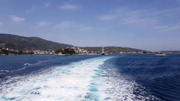 trilha de água espumando atrás de uma balsa a caminho de uma ilha da grécia. foto