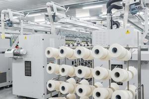 máquinas e equipamentos na oficina para a produção de fios. interior da fábrica têxtil industrial foto