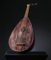 antigo instrumento musical de cordas asiático em fundo preto com luz de fundo foto