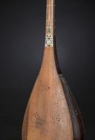 parte instrumento musical de cordas asiático antigo em fundo preto com luz de fundo foto