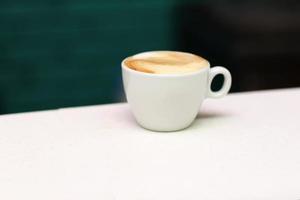 xícara de café em uma mesa branca foto