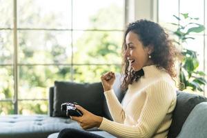 mulher laitin jogando videogame com as mãos segurando um joystick foto