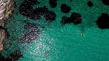 vista aérea acima do mergulhador, nas águas rasas, transparentes do mar egeu, grécia. de cima para baixo, tiro de drone. foto