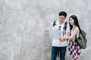 direção de casal asiático viajante no mapa de localização em pequim, china, doce casal asiático olhando no mapa encontrar marco enquanto passa a viagem de férias. casal de estilo de vida viaja no conceito de cidade. foto