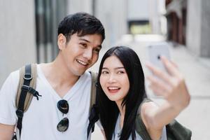 casal de blogueiros asiáticos viaja em pequim, china, doce casal usando a visualização de foto de selfie de telefone celular enquanto passa um tempo doce na viagem de férias. casal viaja no conceito de cidade.