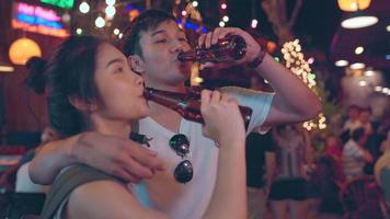 viajante mochileiro casal asiático viaja em bangkok, tailândia, doce casal bebendo álcool ou cerveja enquanto frequenta a estrada khao san. casal viaja no conceito de tailândia. foto
