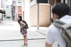 casal asiático viajante viaja em pequim, china, doce casal usando câmera tirando foto um do outro perto da rua enquanto passava a viagem de férias. casal de estilo de vida viaja no conceito de cidade.