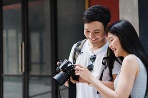 casal asiático viajante usando a câmera para tirar uma foto enquanto passava a viagem de férias em pequim, china, casal gosta de viajar em um marco incrível na cidade. casal de estilo de vida viaja no conceito de cidade.