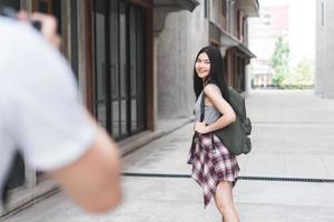 casal asiático viajante viaja em pequim, china, doce casal usando câmera tirando foto um do outro perto da rua enquanto passava a viagem de férias. casal de estilo de vida viaja no conceito de cidade.