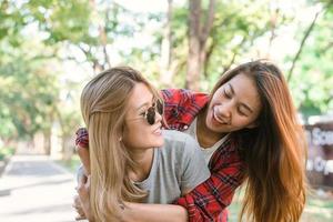 feliz jovem casal de mulheres asiáticas jogando um para o outro enquanto fazem uma viagem à cidade no fim de semana de manhã de sol quente. estilo de vida da cidade e da natureza de mulheres jovens. estilo de vida no conceito de atividade da cidade. foto