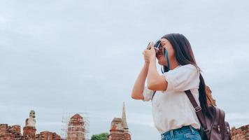 mulher asiática viajante usando a câmera para tirar uma foto enquanto passava a viagem de férias em ayutthaya, tailândia, turista japonesa desfruta de sua jornada no incrível marco na cidade tradicional.