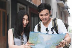 direção de casal asiático viajante no mapa de localização em pequim, china, doce casal asiático olhando no mapa encontrar marco enquanto passa a viagem de férias. casal de estilo de vida viaja no conceito de cidade. foto