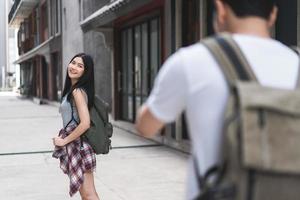 casal asiático viajante viaja em pequim, china, doce casal usando câmera tirando foto um do outro perto da rua enquanto passava a viagem de férias. casal de estilo de vida viaja no conceito de cidade.