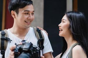 casal asiático viajante usando a câmera para tirar uma foto enquanto passava a viagem de férias em pequim, china, casal gosta de viajar em um marco incrível na cidade. casal de estilo de vida viaja no conceito de cidade.