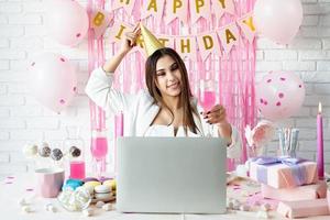 linda mulher comemorando aniversário usando videochamada conversando com amigos foto