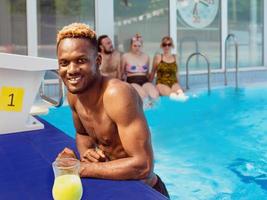 homem afro-americano com mulher caucasiana na piscina. verão. férias, diversidade e conceito de esporte. foto