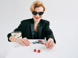 mulher elegante madura de smoking preto e óculos de sol felizes em ganhar no cassino. jogos de azar, moda, conceito de hobby. foto