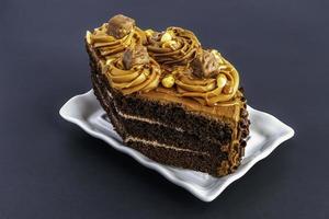 bolo de chocolate. uma fatia de bolo de chocolate em um fundo cinza foto