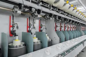 máquinas e equipamentos na oficina para a produção de fios. fábrica têxtil industrial foto