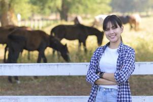 jovem agricultor com cavalos no pasto, paisagem de verão do país. foto