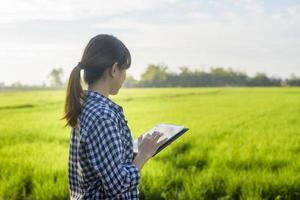 jovem agricultora inteligente com tablet em campo, inovações de alta tecnologia e agricultura inteligente foto