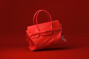bolsa vermelha acessórios de moda feminina flutuando no fundo vermelho. ideia de conceito mínimo criativa. estilo origami. renderização 3D. foto