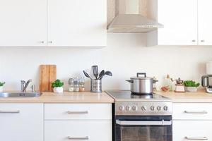 cozinha minimalista clássica escandinava com detalhes em branco e madeira. cozinha branca moderna limpa design de interiores de estilo contemporâneo. foto