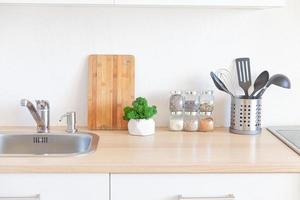 cozinha minimalista clássica escandinava com detalhes em branco e madeira. cozinha branca moderna limpa design de interiores de estilo contemporâneo. foto