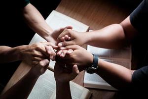 os cristãos são congregantes dão as mãos para orar e buscar as bênçãos de Deus. conceito de reunião devocional ou oração. foto