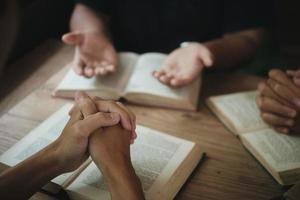 os cristãos são congregantes dão as mãos para orar e buscar as bênçãos de Deus. conceito de reunião devocional ou oração. foto