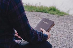 homem segurando a bíblia sagrada pronta para ler e ter relacionamento com o conceito cristão de fé, espiritualidade e religião de deus. foto