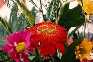 um par de anéis de casamento em um buquê de flores foto