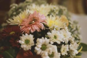 um par de anéis de casamento em um buquê de flores foto