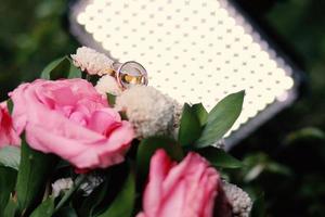 um par de anéis de casamento em um buquê de flores foto