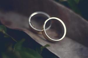 um par de anéis de casamento em uma madeira foto