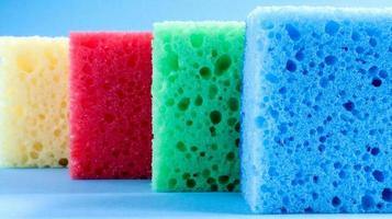 muitas esponjas azuis, vermelhas, amarelas e verdes são usadas para lavar e limpar a sujeira usada pelas donas de casa no dia a dia. eles são feitos de material poroso, como espuma. boa retenção de detergente foto