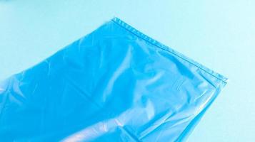 um saco de lixo plástico rasgado em azul sobre um fundo azul. um saco que é projetado para acomodar o lixo e é usado em casa e colocado em vários recipientes de lixo. foto