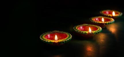 happy diwali - lâmpadas diya de argila acesas durante a celebração do diwali. design de cartão de cumprimentos do festival indiano da luz hindu chamado diwali foto